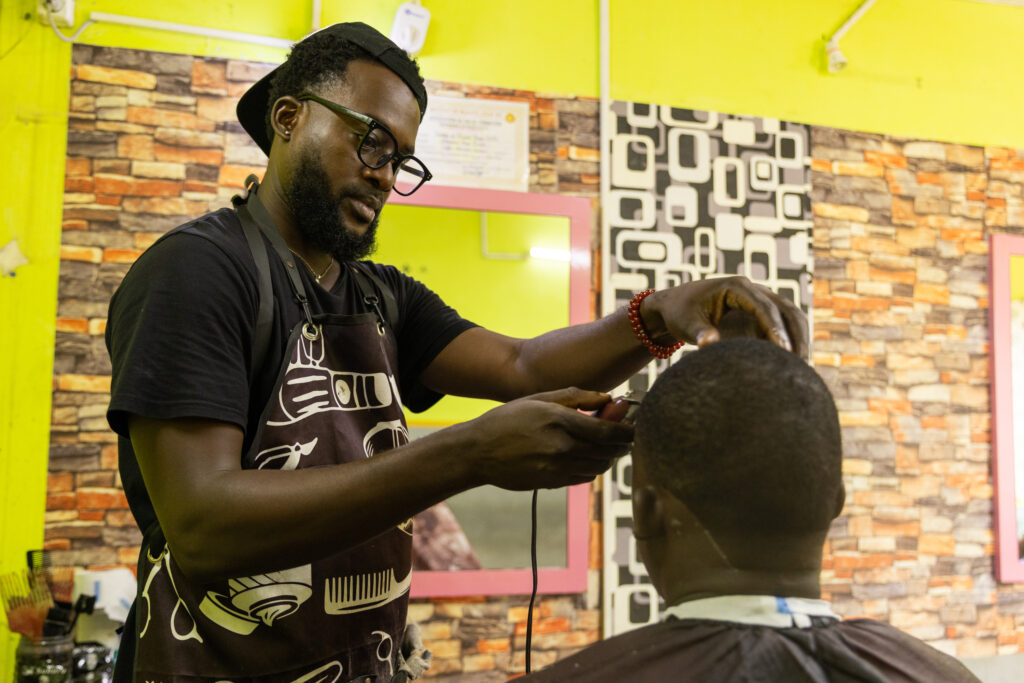 a barber is focused on cutting his client's hair in his salon